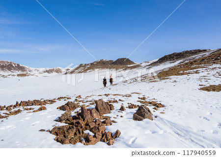 Two riders on white snowy mountain slope. 117940559