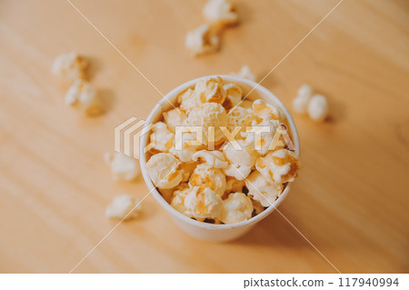 A bucket of popcorn, top-view, warm colors, light brown wooden background, flat lay, daylight macro close-up A bucket of popcorn, top-view, warm colors, light brown wooden background, flat lay, daylight macro close-up 117940994