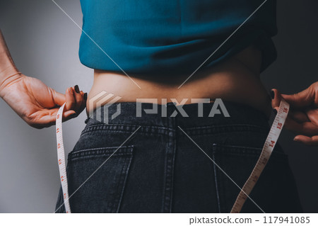 fat woman, fat belly, chubby, obese woman hand holding excessive belly fat with measure tape, woman diet lifestyle concept fat woman, fat belly, chubby, obese woman hand holding excessive belly fat with measure tape, woman diet lifestyle concept 117941085