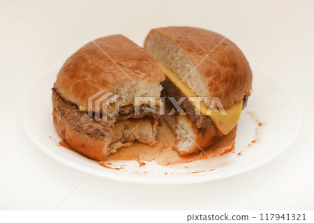 Cheeseburger on a white background. Meat burger cut into slices. Cheeseburger on a white background. Meat burger cut into slices. 117941321