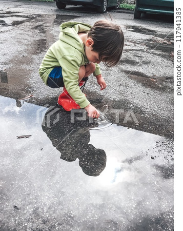 Little boy and a big puddle after the rain 117941385