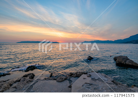 Colorful sunset on Makarska Riviera, popular touristic coastline of the Adriatic Sea in Split-Dalmatia County of Croatia Colorful sunset on Makarska Riviera, popular touristic coastline of the Adriatic Sea in Split-Dalmatia County of Croatia 117941575