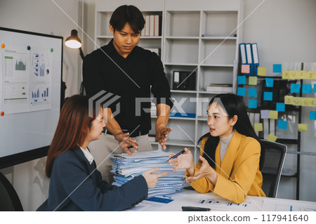 Financial analysts analyze business financial reports on a digital tablet planning investment project during a discussion at a meeting of corporate showing the results of their successful teamwork. 117941640