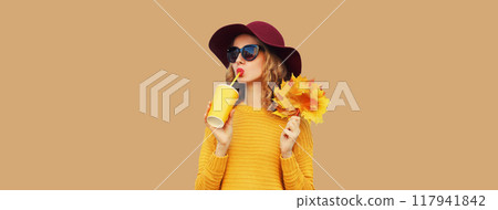 Autumn portrait of beautiful smiling young woman with yellow maple leaves, cup of coffee drink Autumn portrait of beautiful smiling young woman with yellow maple leaves, cup of coffee drink 117941842