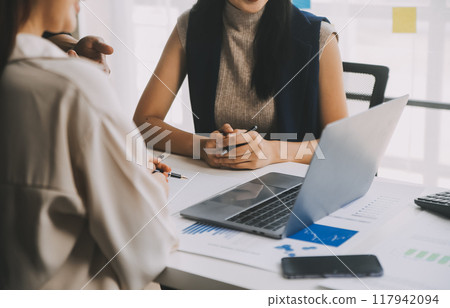 Financial analysts analyze business financial reports on a digital tablet planning investment project during a discussion at a meeting of corporate showing the results of their successful teamwork. 117942094