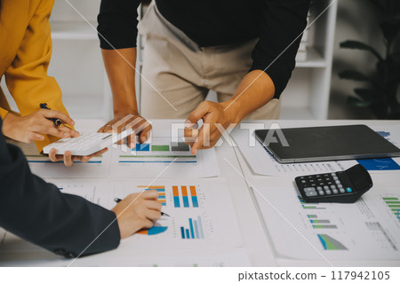 Financial analysts analyze business financial reports on a digital tablet planning investment project during a discussion at a meeting of corporate showing the results of their successful teamwork. 117942105