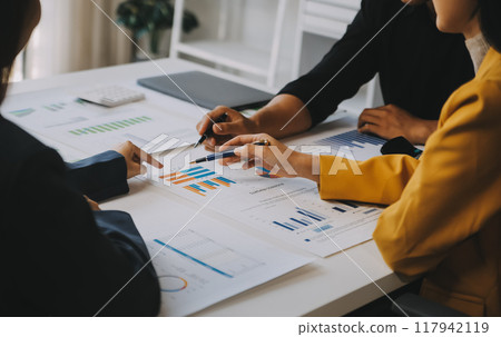 Financial analysts analyze business financial reports on a digital tablet planning investment project during a discussion at a meeting of corporate showing the results of their successful teamwork. 117942119