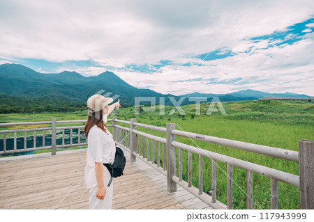 A woman walking along a trail in Shiretoko National Park 117943999