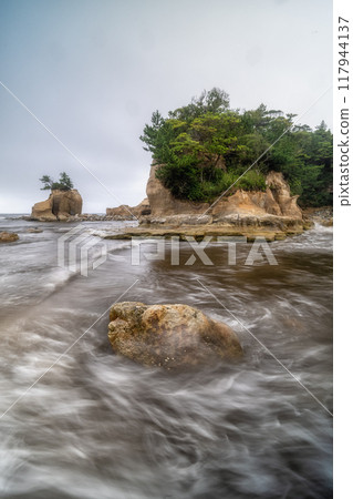一個小島，天空多雲，波濤洶湧 117944137