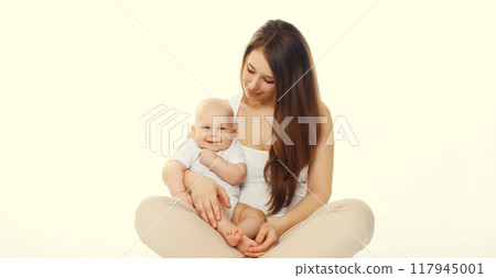 Happy smiling young mother playing with cute baby sitting together on the floor on white background 117945001