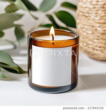Amber glass candle jar mockup, cylindrical amber candle with blank label, candle burning, cozy sunny bright home interior decor 117945239