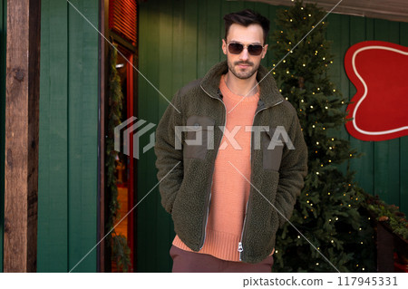 Handsome man in trendy clothes standing near Handsome man in trendy clothes standing near 117945331