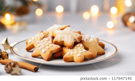 Homemade Christmas gingerbread cookies decorated with sweet sugar icing served on plate on white wooden background 117947140