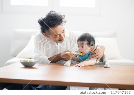 Dad giving baby food to his baby 117947192