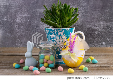 Succulent in a cup, Easter decorated egg, candies and bunny. 117947279