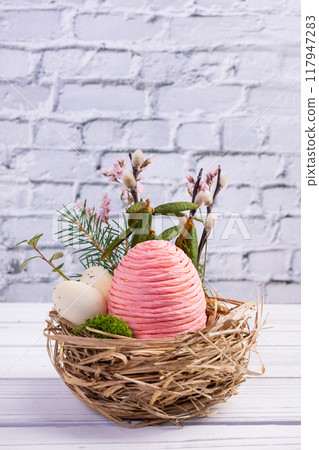 Easter decor nest with eggs, flowers and branches. 117947283