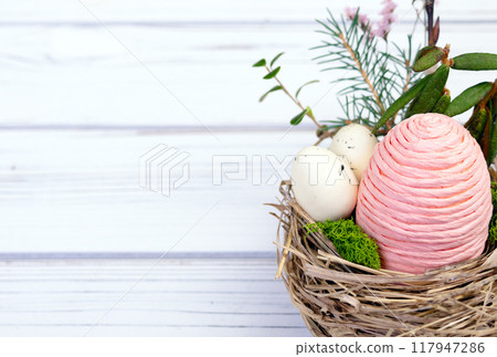 Easter decor nest with eggs, flowers and branches. 117947286