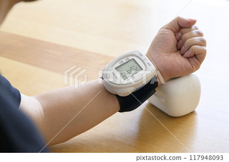 Man measuring blood pressure at home Man measuring blood pressure at home 117948093