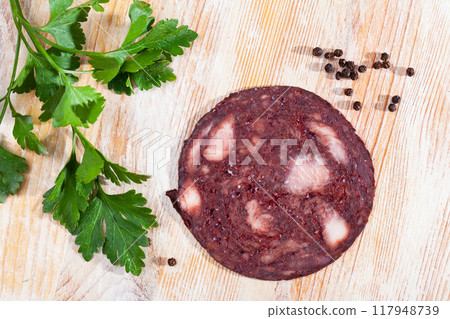 Sliced Catalan black botifarra with fresh parsley and peppercorns 117948739