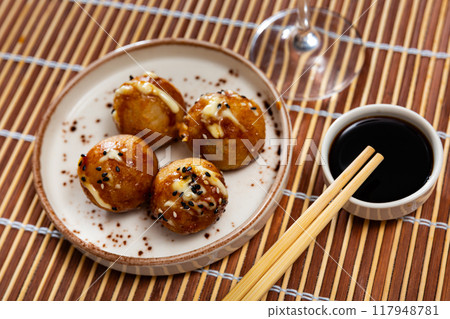 Toasted takoyaki balls containing octopus, seasoned with ketchup and mayonnaise. 117948781