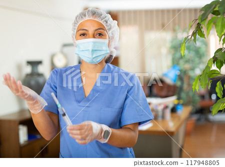 Confident woman doctor holding syringe for injection 117948805