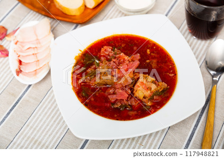 Borsch in bowl on table with salo and smetana 117948821