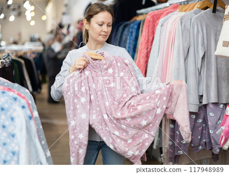 Middle-aged woman choosing convenient pajamas in clothing store 117948989