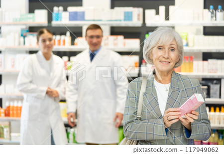 In pharmacy, senior female customer chooses cream for aging skin 117949062