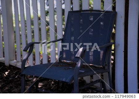 Blue chair by white fence 117949063