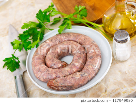 Sausages served with herbs to table 117949080