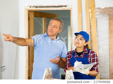 Woman worker talking with man owner of apartment about renovation works Woman worker talking with man owner of apartment about renovation works 117949086