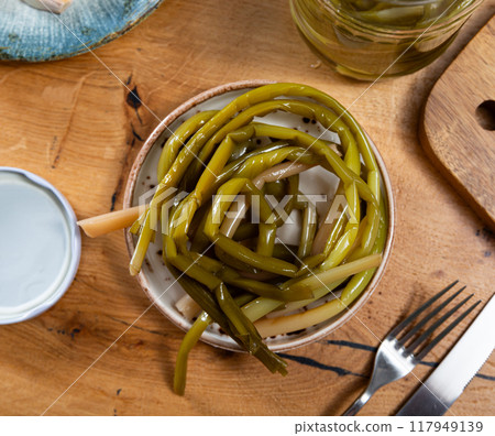Pickled wild garlic scapes served in ceramic bowl Pickled wild garlic scapes served in ceramic bowl 117949139