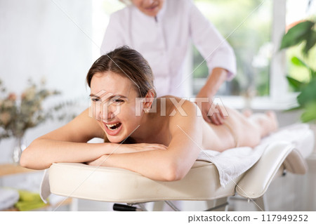 Female client experiencing discomfort during back massage session Female client experiencing discomfort during back massage session 117949252