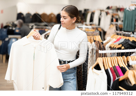 Young woman choosing coat in store 117949312