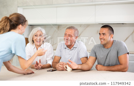 Family of four sits at table and talking Family of four sits at table and talking 117949342