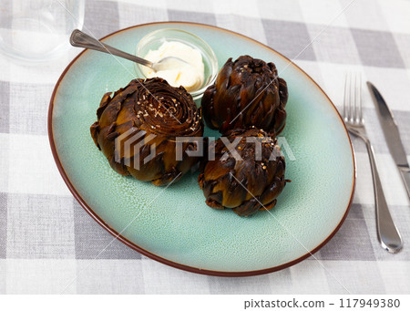 Three whole roasted artichokes with hollandaise sauce 117949380