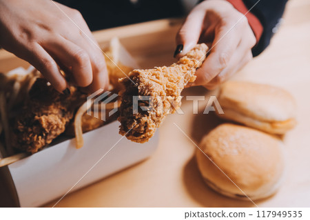 close up focus woman hand hold fried chicken for eat,girl with fast food concept 117949535