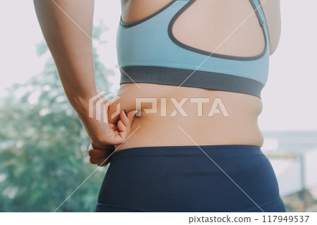 fat woman, fat belly, chubby, obese woman hand holding excessive belly fat with measure tape, woman diet lifestyle concept 117949537