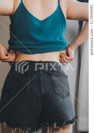 fat woman, fat belly, chubby, obese woman hand holding excessive belly fat with measure tape, woman diet lifestyle concept 117949561