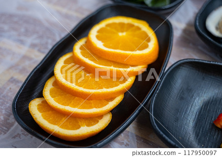 Sliced orange on a plate Sliced orange on a plate 117950097