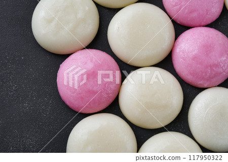 Red and white round rice cakes on a black background, copy space available Red and white round rice cakes on a black background, copy space available 117950322