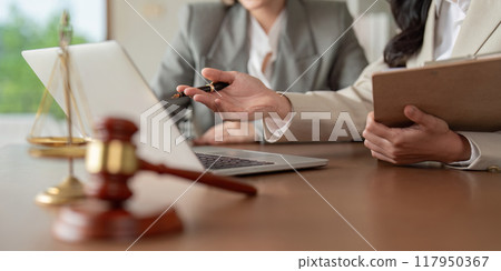 Lawyers discussing legal matters using laptop and documents 117950367