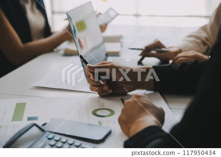 Financial analysts analyze business financial reports on a digital tablet planning investment project during a discussion at a meeting of corporate showing the results of their successful teamwork. 117950434
