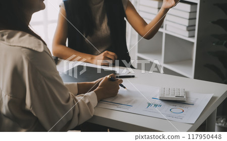 Financial analysts analyze business financial reports on a digital tablet planning investment project during a discussion at a meeting of corporate showing the results of their successful teamwork. Financial analysts analyze business financial reports on a digital tablet planning investment project during a discussion at a meeting of corporate showing the results of their successful teamwork. 117950448