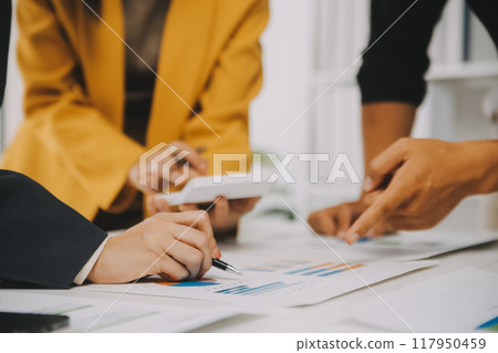 Financial analysts analyze business financial reports on a digital tablet planning investment project during a discussion at a meeting of corporate showing the results of their successful teamwork. 117950459