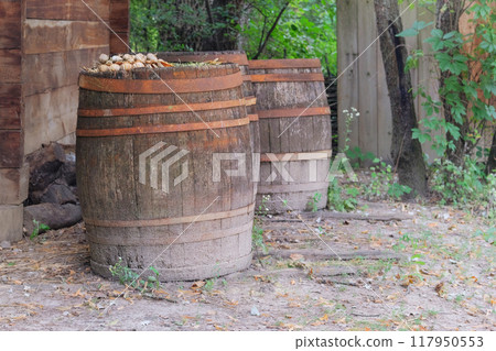 Wooden barrels with metal hoops. Countryside. 117950553