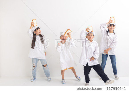 Elementary school student wearing school lunch uniform and holding bread 117950641