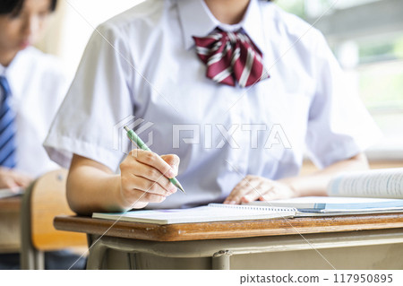 Hands of a female high school student taking a class 117950895