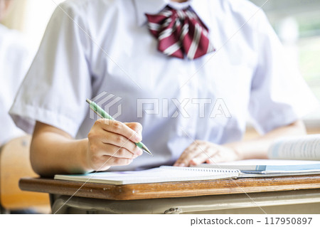 Hands of a female high school student taking a class Hands of a female high school student taking a class 117950897