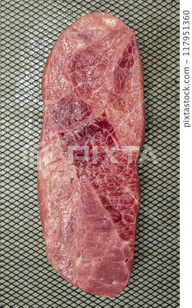 A piece of sirloin meat is sliced and placed on a baking sheet 117951360